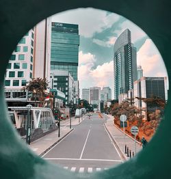 City street by modern buildings against sky