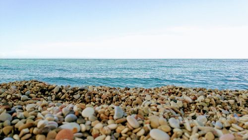 View of pebbles on beach against sky