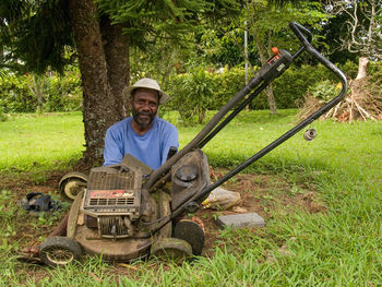 Portrait of a smiling young man sitting on field