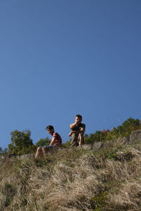 Men on field against clear sky