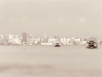 Boats in sea against clear sky