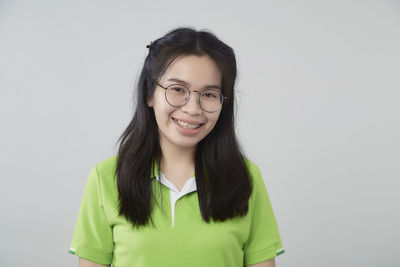 Portrait of smiling young woman against white background