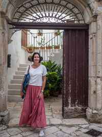 Portrait of a smiling young woman standing outdoors in locorotondo, italy.