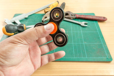 Close-up of hand holding eyeglasses on table