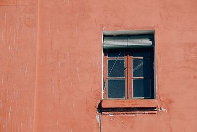 Window on the red facade of the building on the street