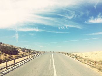 Tire tracks on road against sky