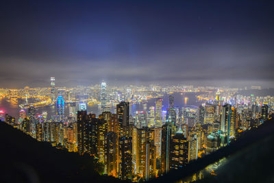 Illuminated cityscape against sky at night