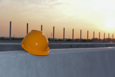 Close-up of yellow hat against sky during sunset