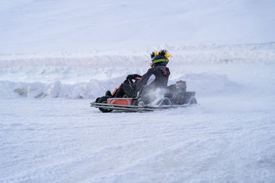 Go karting on icy track in winter. adult karting driver in action on outdoor icy track 