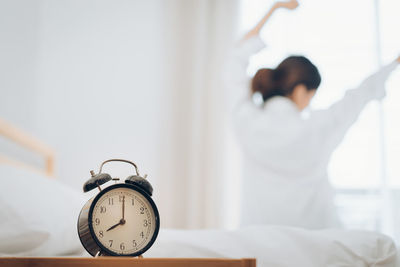 Portrait of woman with arms raised on bed