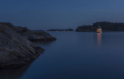 Scenic view of yacht against clear blue sky at night