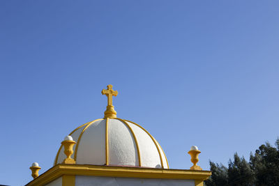 Low angle view of the roof of a mausoleum against clear blue sky