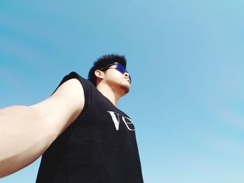 Low angle view of man against clear blue sky