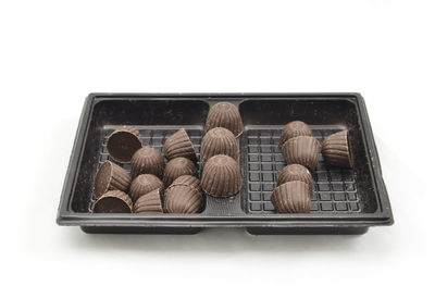 High angle view of candies in box against white background