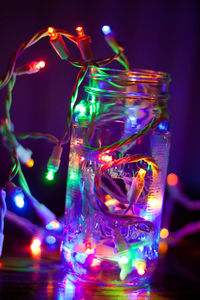 Illuminated christmas lights in glass jar on table