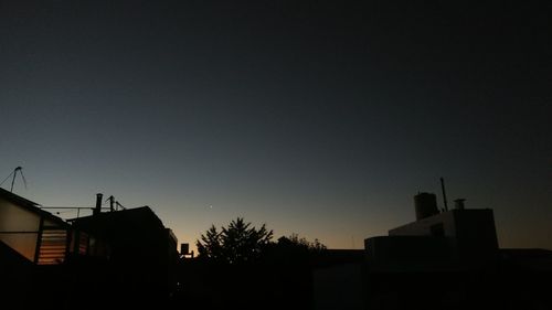 Low angle view of silhouette buildings against sky at night