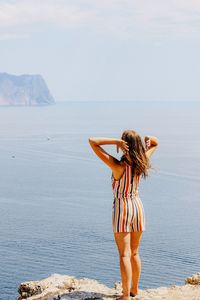 Rear view of woman looking at sea against sky