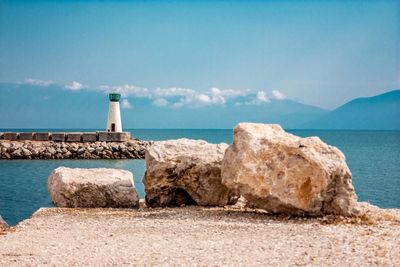 Lighthouse by sea against sky