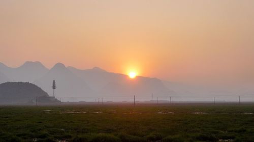 Scenic view of field against sky during sunset