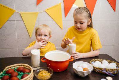 Kids prepare dough for holiday cupcake holiday easter, eggs on the table