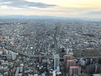 High angle view of modern city buildings against sky during sunset