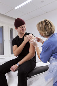 Smiling young man getting vaccinated against covid-19