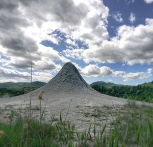 Scenic view of land against cloudy sky