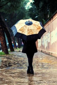 Full length of man with umbrella walking in rain