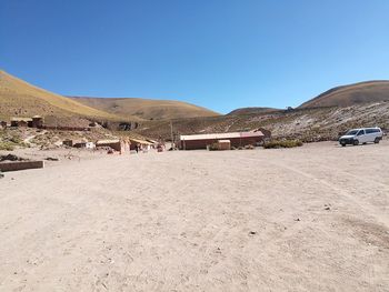 Scenic view of desert against clear blue sky