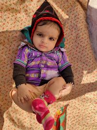 High angle view of cute baby girl sitting at home