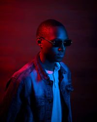 Portrait of young man standing against wall