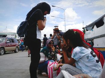 Crowd on road against sky