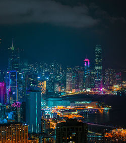 Illuminated buildings in city against sky at night