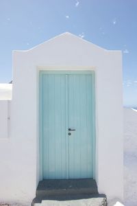 Closed door of building against blue sky