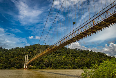 Suspension iron cable bridge isolated with bright blue sky from unique different angle