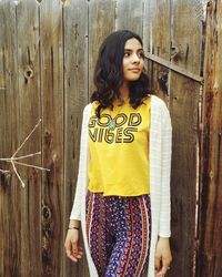 Portrait of young woman standing against door