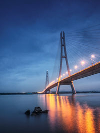 Suspension bridge over river against sky