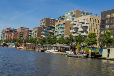 Boats in river with buildings in background