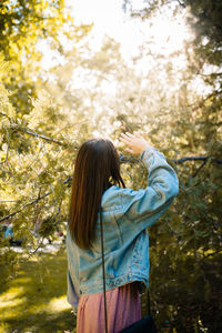 Rear view of woman standing in forest