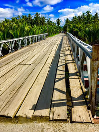 Footpath by railing against sky