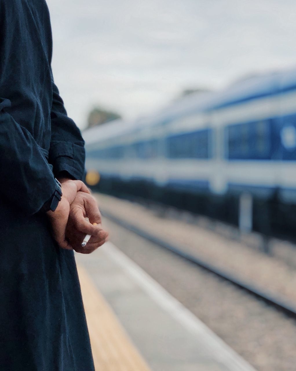 MAN STANDING ON RAILROAD TRACK