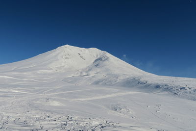 Scenic view of snowcapped mountains against clear blue sky