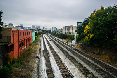 Railroad tracks in city against sky