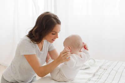 Mother helping child to sit