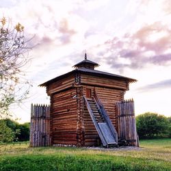 Built structure on field against cloudy sky