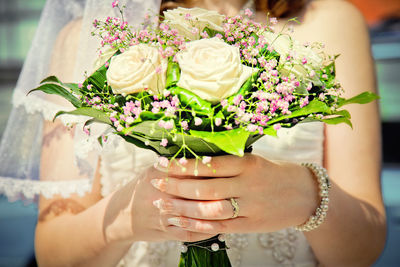 Midsection of woman holding flower bouquet