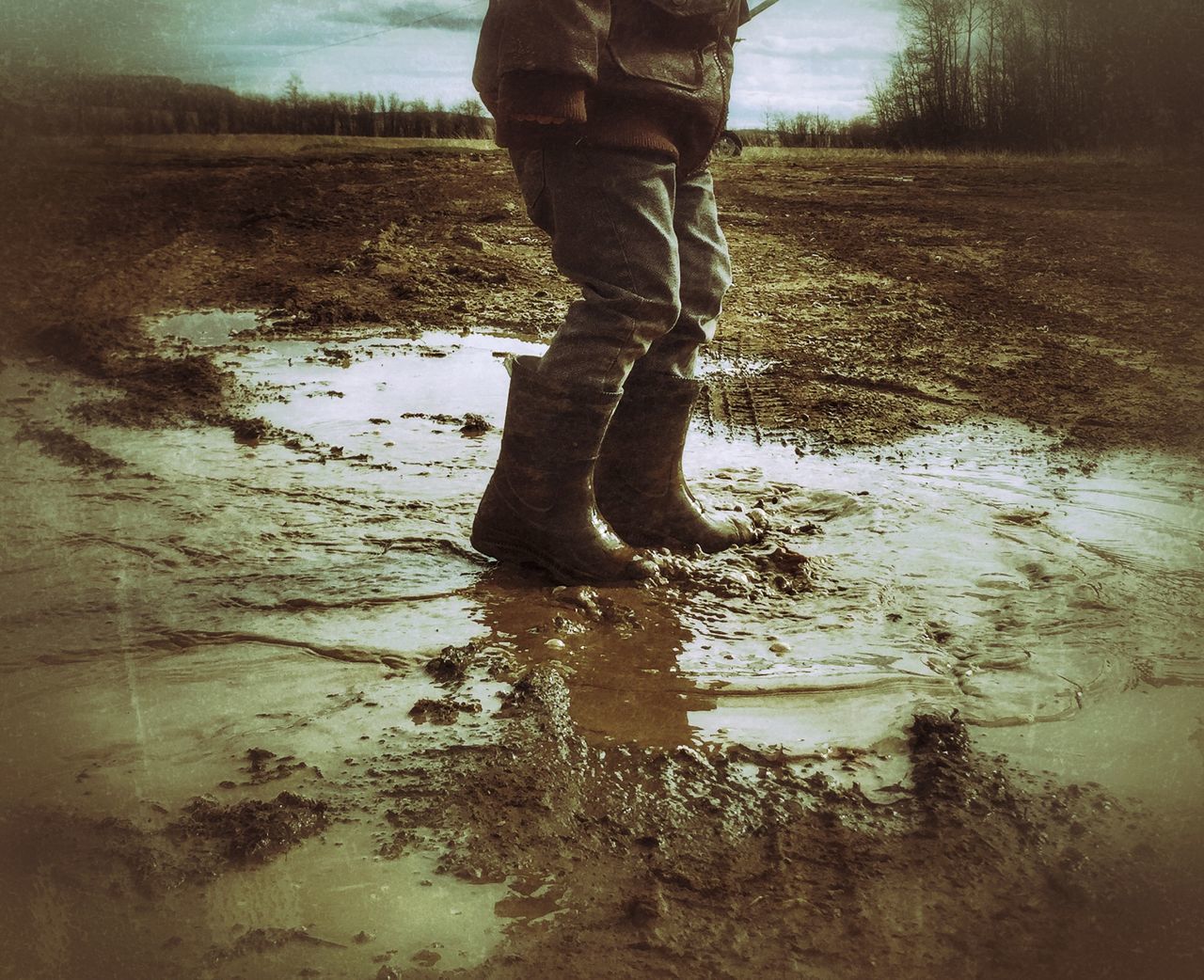 low section, lifestyles, standing, water, person, reflection, leisure activity, lake, puddle, tree, walking, nature, field, outdoors, day, tranquility, season, shoe