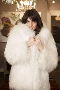 Portrait of confident owner wearing fur coat at boutique