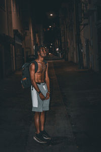 Full length of young man standing out at night stargazing 