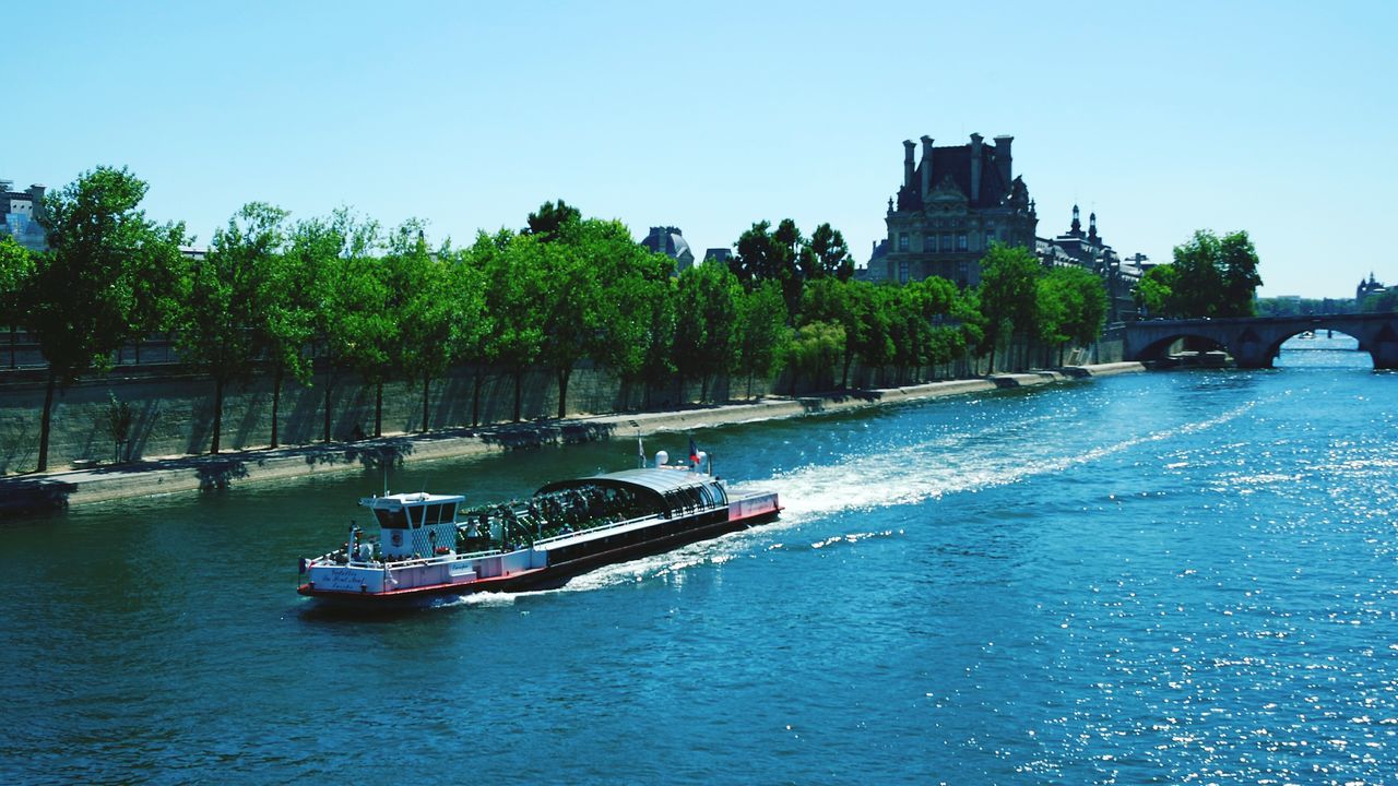 tree, water, transportation, clear sky, nautical vessel, mode of transport, architecture, building exterior, built structure, boat, waterfront, blue, river, city, moored, copy space, incidental people, day, outdoors, nature